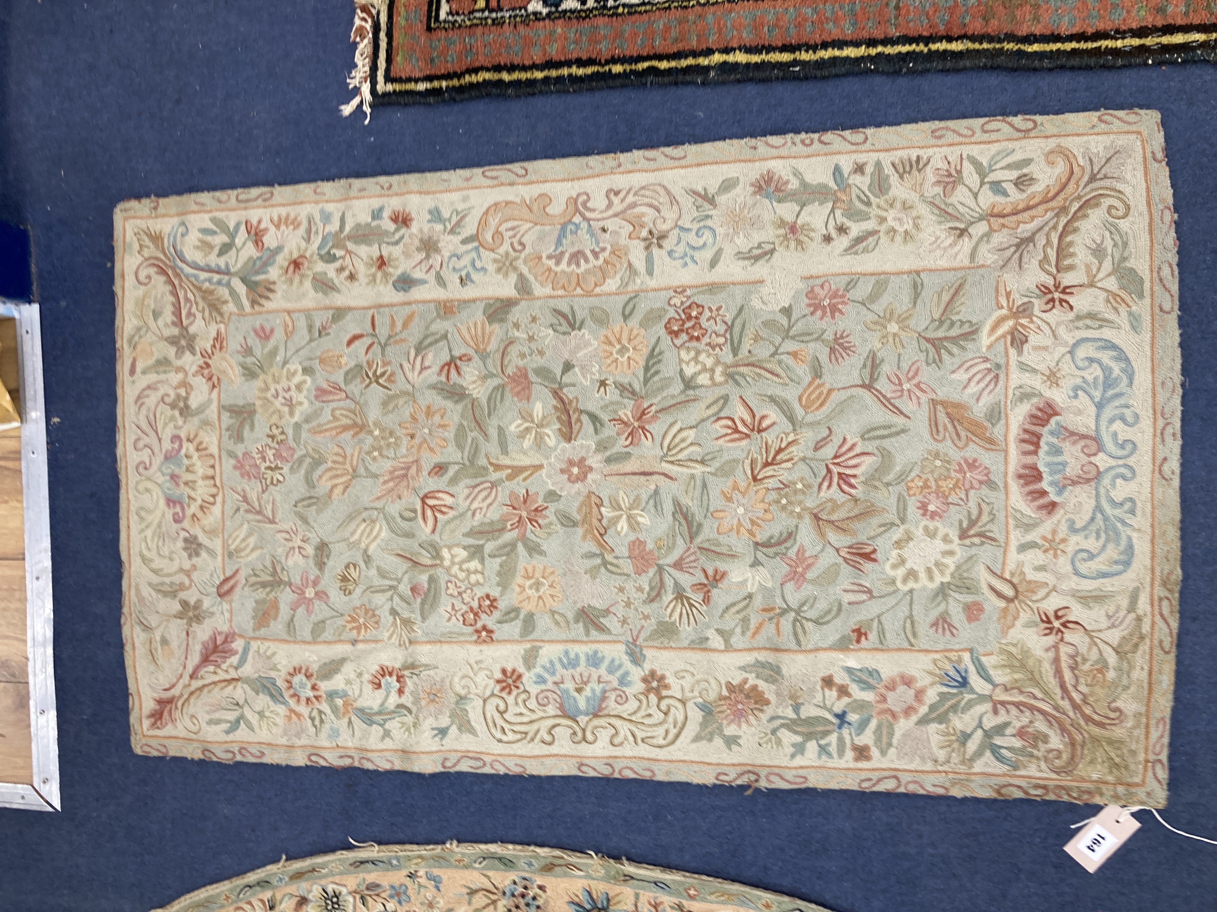 An Antique chainstitch rug, with central field of flowers on a pale blue ground, 122 x 70cm